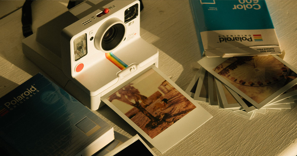 cámara-polaroid-bancos-de-imagenes-gratis Cámara de fotos instantánea rodeada de fotografías